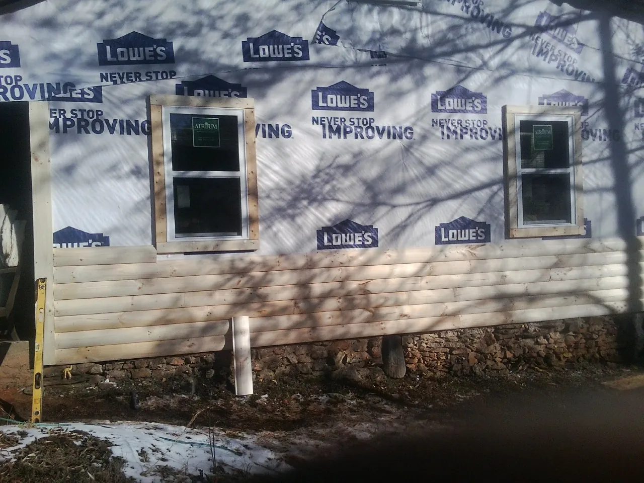 House wrap and new log siding going up on an exterior wall in Whitesboro