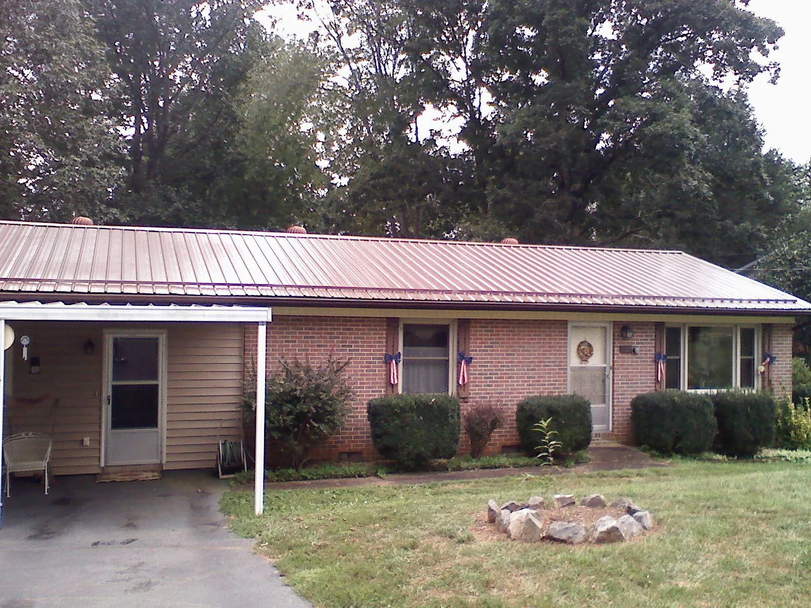 Bronze metal roof and carport on a brick ranch home — Roof Repair work by our crew in Whitesboro